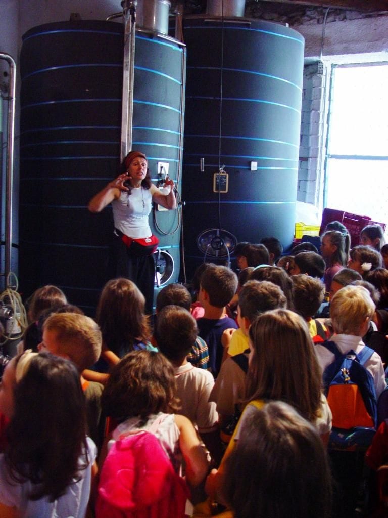 A group of children listening to a woman giving a tour at Georgas Family winery facilities